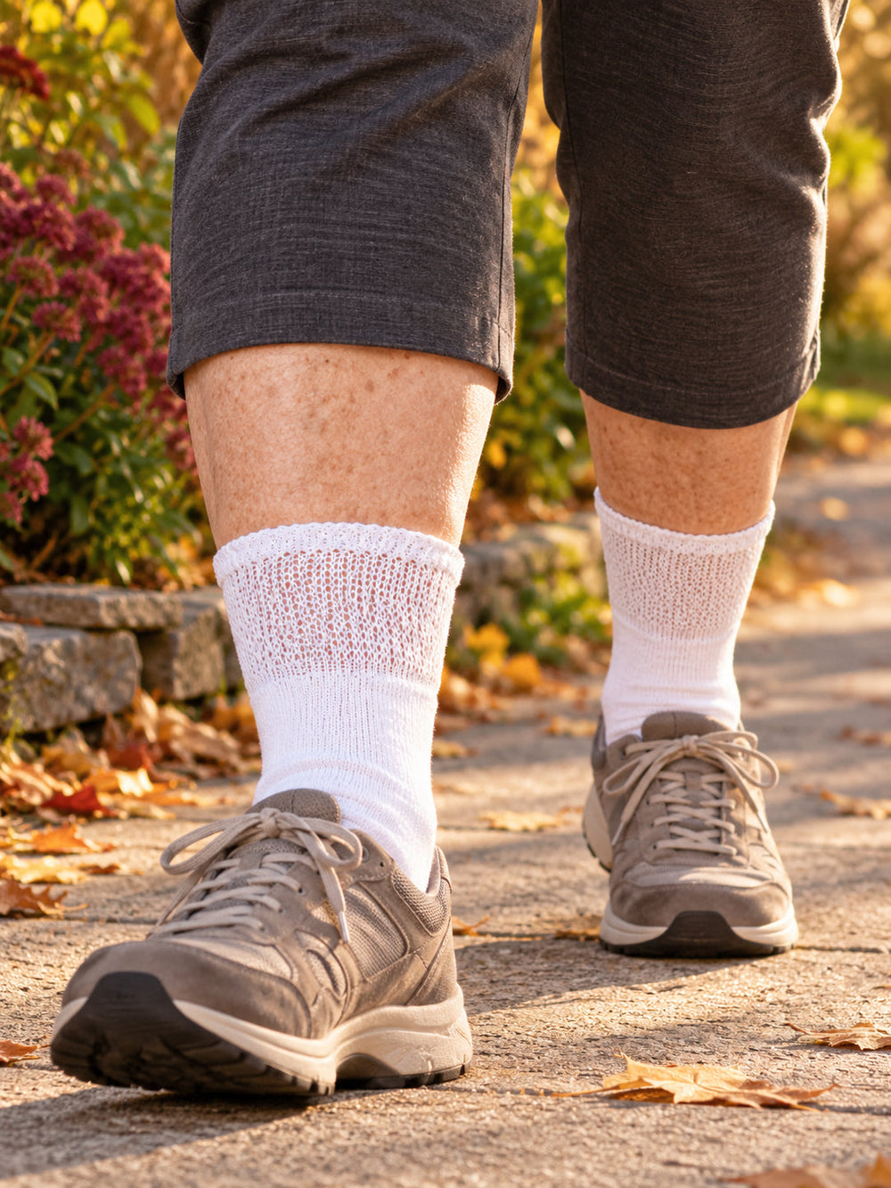 Close view of white non-binding diabetic crew socks and walking shoes on an autumn path